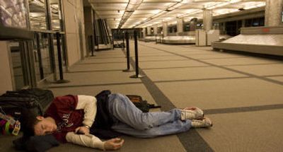
A man sleeps on the floor early Friday at Denver International Airport, where he spent the night after a second snowstorm hit the Denver area, delaying and canceling some flights. 
 (Associated Press / The Spokesman-Review)