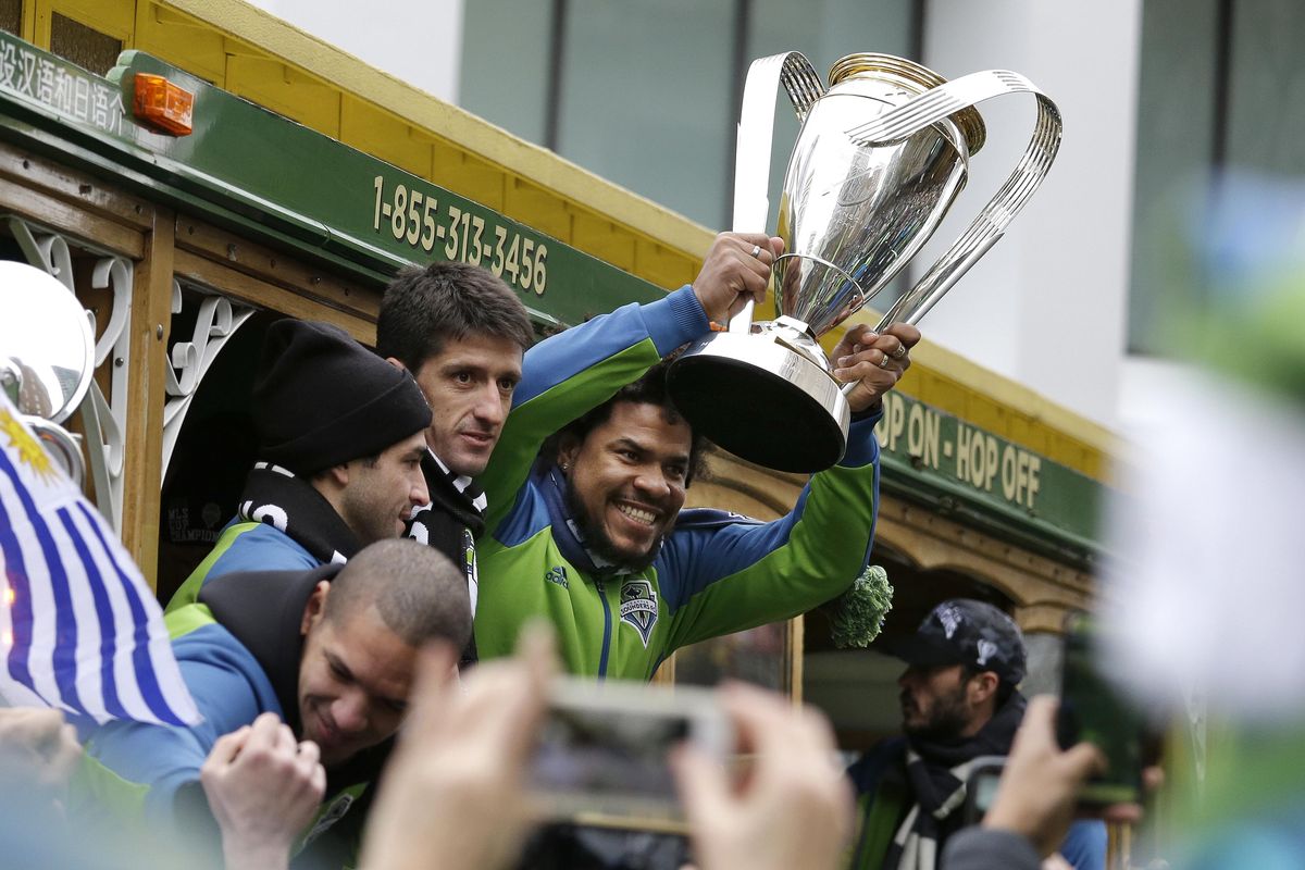Seattle Sounders’ Roman Torres holds the MLS Cup as the team begins a march and rally celebrating their championship, Tuesday, Dec. 13, 2016, in Seattle. Seattle beat Toronto FC 5-4 in a penalty kick shootout Saturday to win their first MLS Cup. (Elaine Thompson / Associated Press)