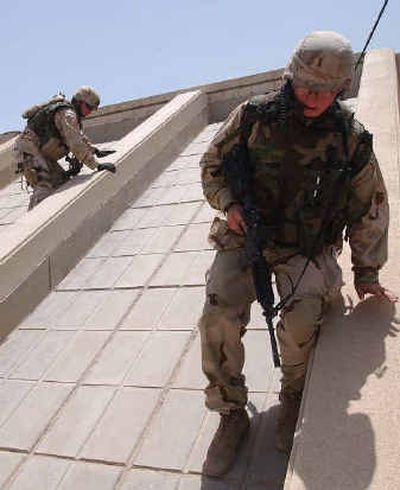 
U.S. soldiers check a rooftop after a nearby explosion in Baghdad Saturday. Witnesses saw two explosions in central Baghdad Saturday, one outside the U.S.-led coalition headquarters near 