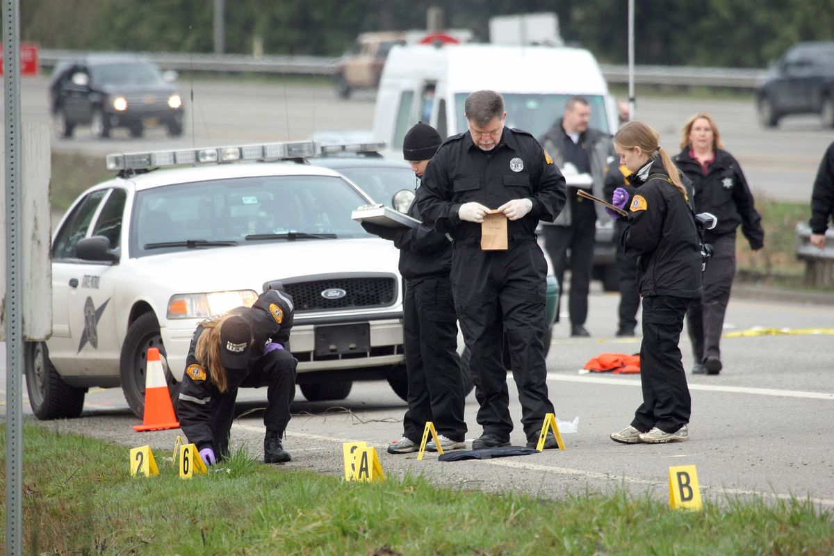 Washington State Patrol investigators gather evidence at the scene of a shooting on Highway 16 in Gorst near Bremerton, Wash., where Trooper Tony Radulescu was shot and killed on Thursday. (Associated Press)
