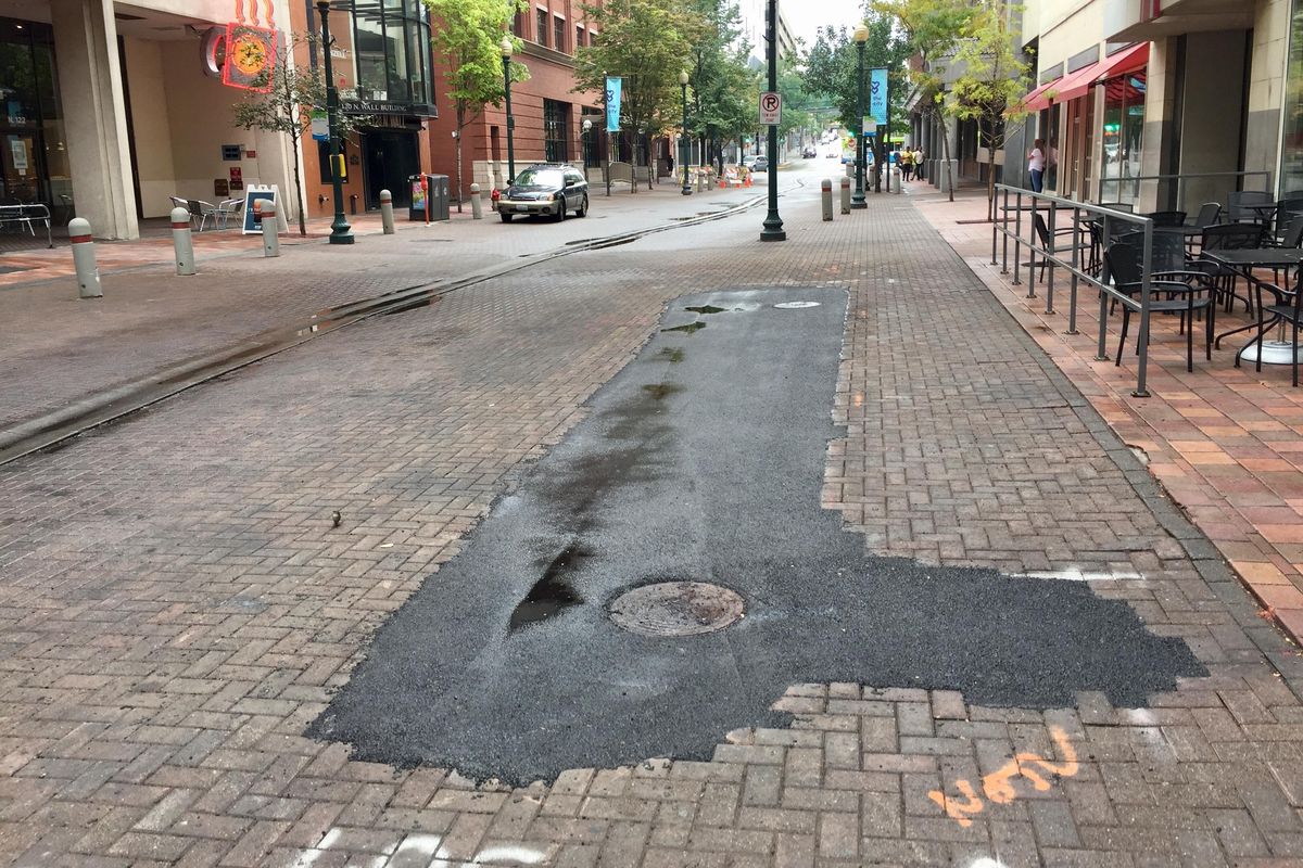 Asphalt fills the space left behind after city crews removed a planter to make way for Spokane Transit Authority’s Central City Line. (Nicholas Deshais / The Spokesman-Review)