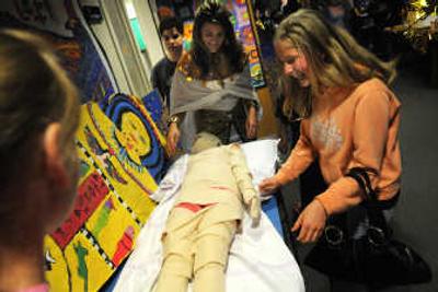 
Inna Chebotareva laughs as her sister Dina gets wrapped as a mummy by sixth-grade teacher Angela Wagner during Night on the Nile at Centennial Middle School  May 29. 
 (Rajah Bose / The Spokesman-Review)