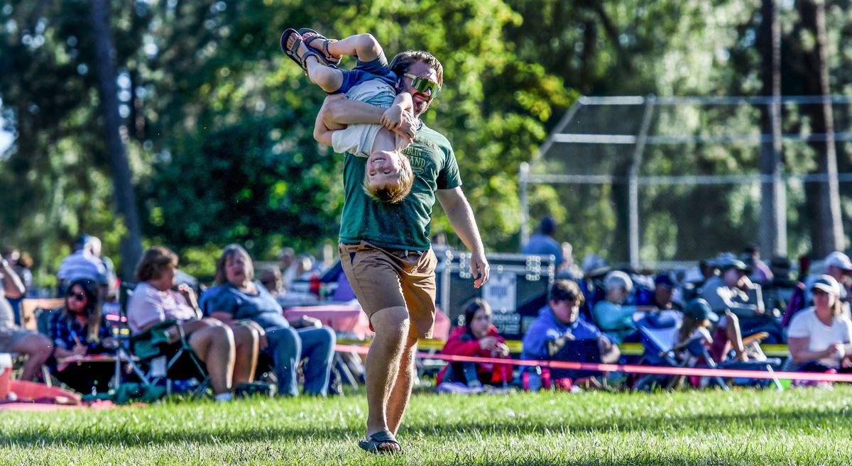 Garrett Hallett carries his son Theo Nevin, 6, through Comstock Park during Spokane Symphony