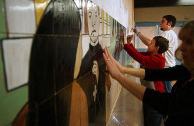 
 Front to back, Shaw Middle School art teacher Shelly Hallsted, Shaw seventh-grader Eugene Pivovarevich, 13, and Rogers High School senior and former Shaw student Brian Schumacher, 18, put up tiles in the new mural at the entrance of Shaw on Sunday.  
 (Liz Kishimoto / The Spokesman-Review)