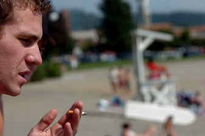 
Austin Bolter, 19, of the Spokane Valley smokes while sitting at Coeur d'Alene's City Beach on Thursday afternoon with a friend. The city is considering a request to ban smoking at the beach.Austin Bolter, 19, of the Spokane Valley smokes while sitting at Coeur d'Alene's City Beach on Thursday afternoon with a friend. The city is considering a request to ban smoking at the beach.
 (Jesse Tinsley/Jesse Tinsley/ / The Spokesman-Review)