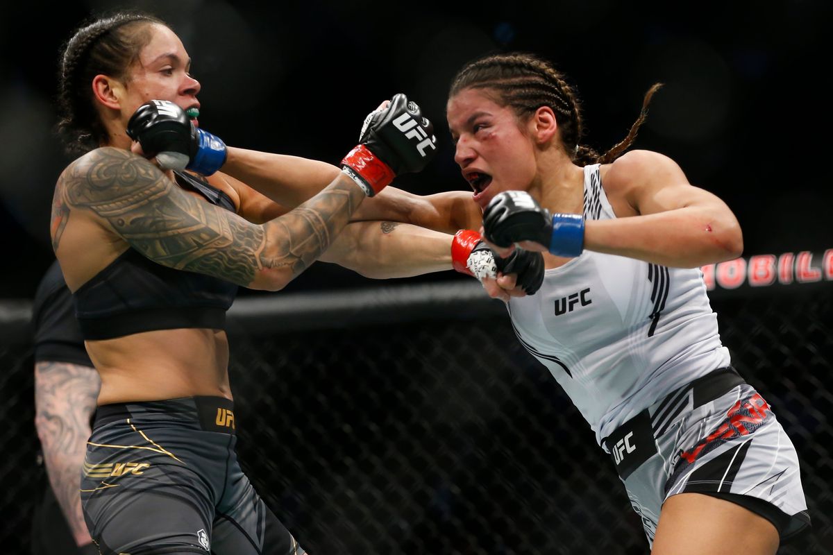 Julianna Pena, right, hits Amanda Nunes during a women