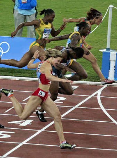 
Yulia Nesterenko of Belarus, left, crosses finish line to win women's 100 meters and end the Americans' streak of five golds in the event. 
 (Associated Press / The Spokesman-Review)