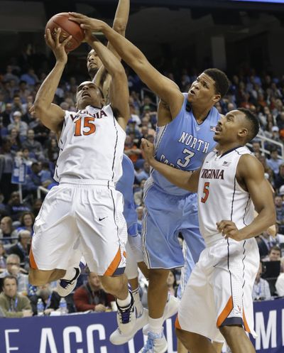 North Carolina’s Kennedy Meeks blocks a shot by Virginia’s Malcolm Brogdon, right. (Associated Press)