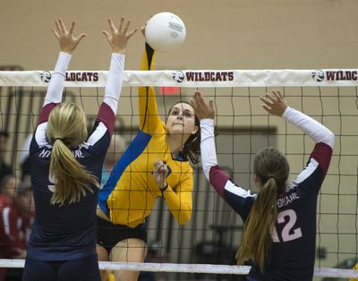 Mead’s Kristina Volz spikes the ball as Mt. Spokane’s Libby Pittenger, left, and Bailey Ricard attempt to block the shot during Thursday night’s match. (Colin Mulvany)