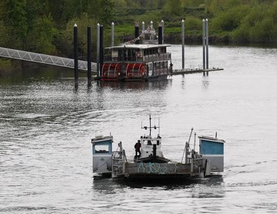 Headed for retirement: The old Buena Vista ferry passes the Willamette Queen as it travels up the Willamette River, through Salem, Ore., toward Portland on Tuesday. The ferry has been in operation for 50 years and will be replaced this summer using federal stimulus funds. (Associated Press)