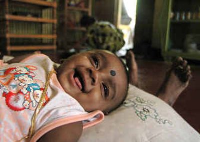 
Abilass Jeyarajah smiles as he is rocked by his relatives at his temporary home Wednesday in the eastern town of Kalmunai, Sri Lanka.
 (Associated Press / The Spokesman-Review)