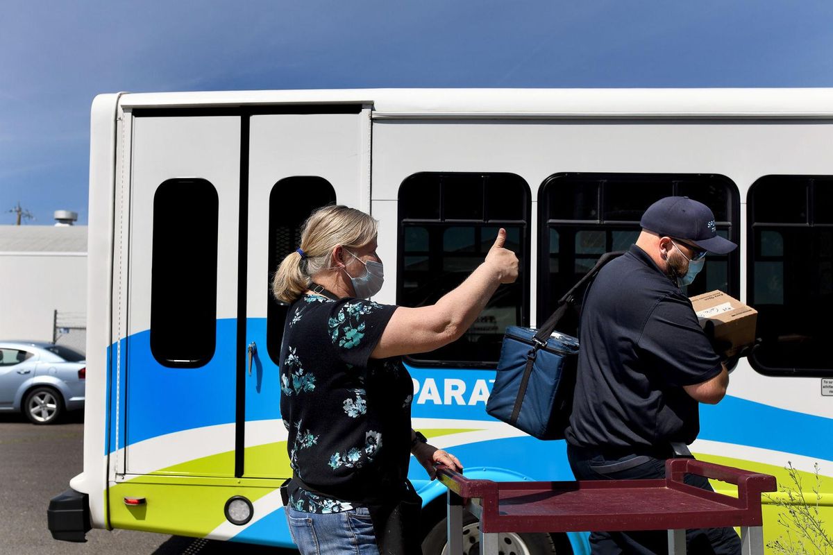 Food service director Jerri Horton of Greater Spokane County Meals on Wheels gives a thumbs up to STA paratransit driver Alex Henry as he carries meals for delivery.  (Kathy Plonka/The Spokesman-Review)