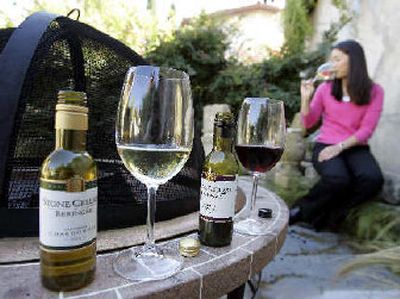 
Beringer Blass' new unbreakable wine bottles are shown in the foreground as Berniece Wong drinks a glass of Stone Cellars' chardonnay in the background in Yountville, Calif. The next big thing for the wine industry is small, screw-capped and shatterproof plastic bottles. 
 (Associated Press / The Spokesman-Review)