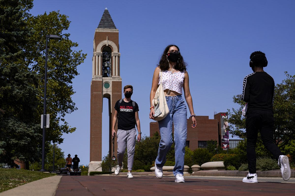 FILE – Masked students walk through the campus of Ball State University in Muncie, Ind., Thursday, Sept. 10, 2020. Colleges across the country are struggling to salvage the fall semester as campus coronavirus cases skyrocket and tensions with local health leaders flare. Schools have locked down dorms, imposed mask mandates, barred student fans from football games and toggled between online and in-person classes.  (Michael Conroy)