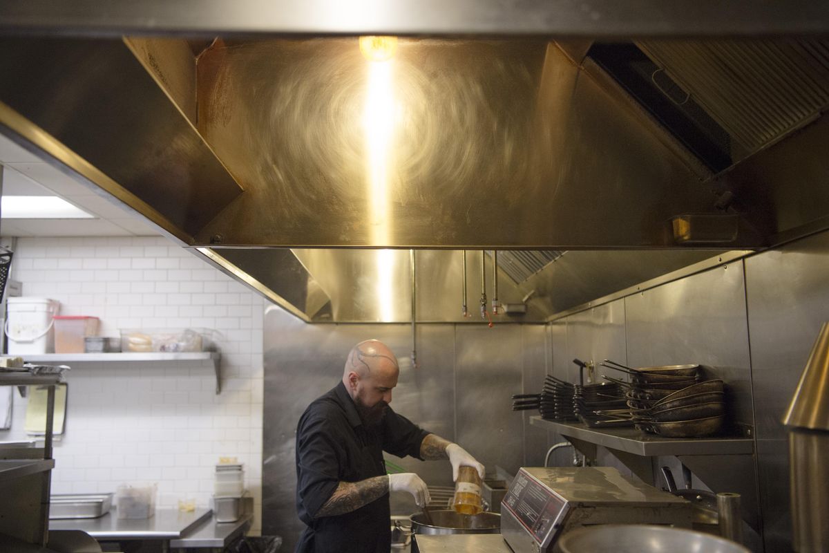 Chef Mike McElroy works to prepare a duck confit cassoulet on Friday, Nov. 4, 2016, at Casper Fry in Spokane, Wash. (Tyler Tjomsland / The Spokesman-Review)