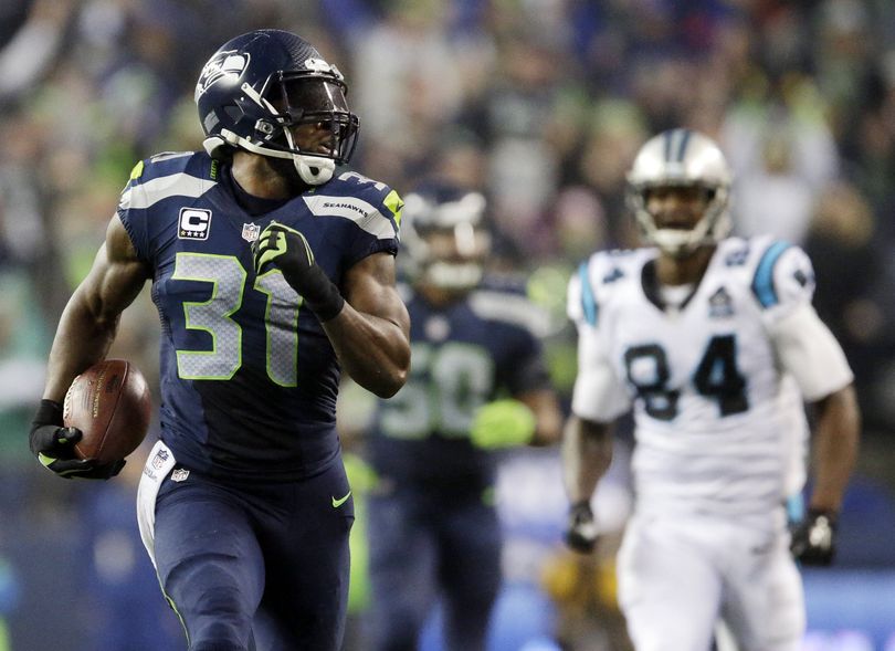 Seahawks safety Kam Chancellor leaves Carolina’s Ed Dickson in rear-view mirror on his way to interception-return touchdown. (Associated Press)