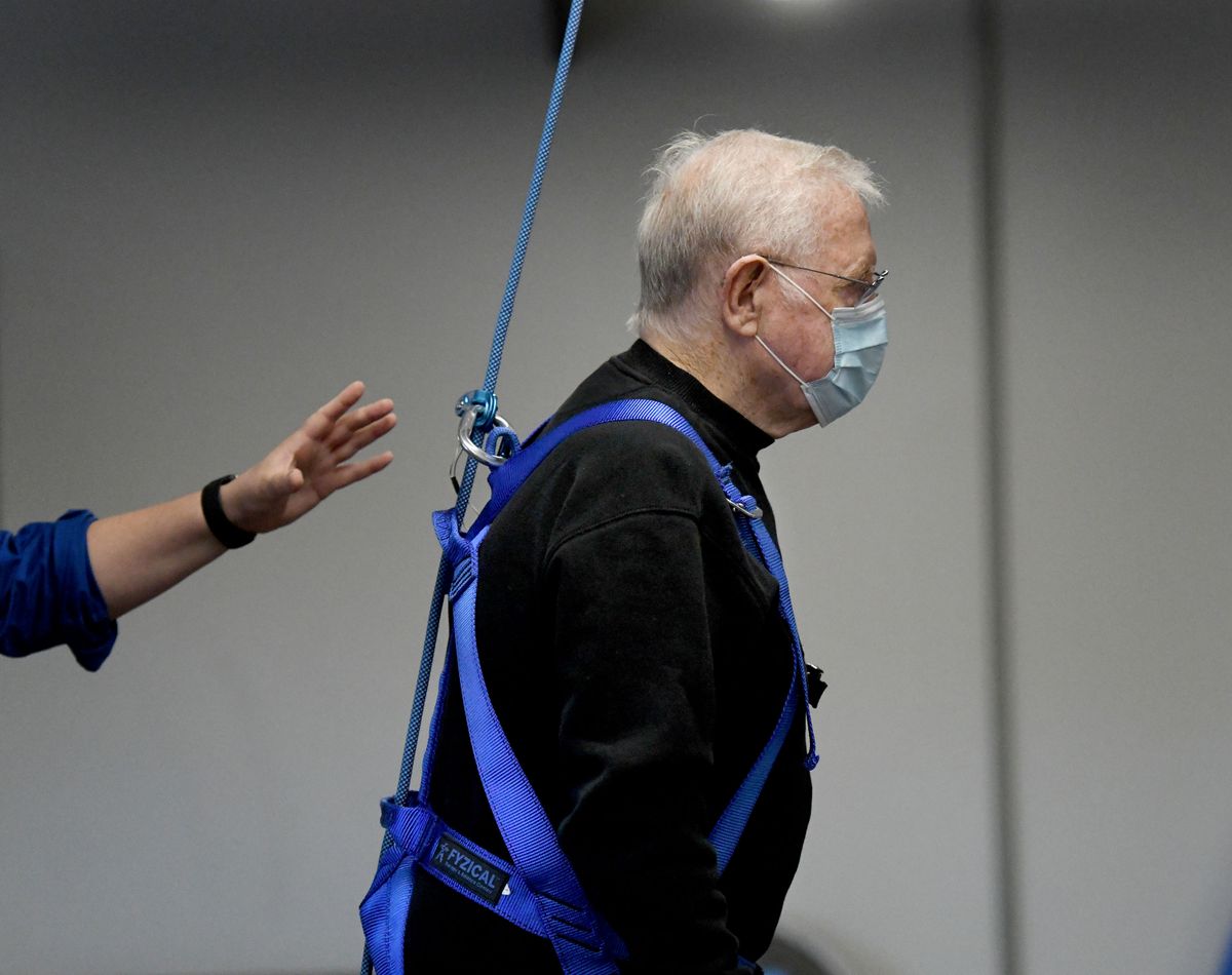 While wearing a harness, Gary Paris of Spokane walks using the overhead support system aided by physical therapist assistant Karen Wilson at Fyzical Therapy &amp; Balance Center in Spokane on Monday.  (Kathy Plonka/The Spokesman-Review)
