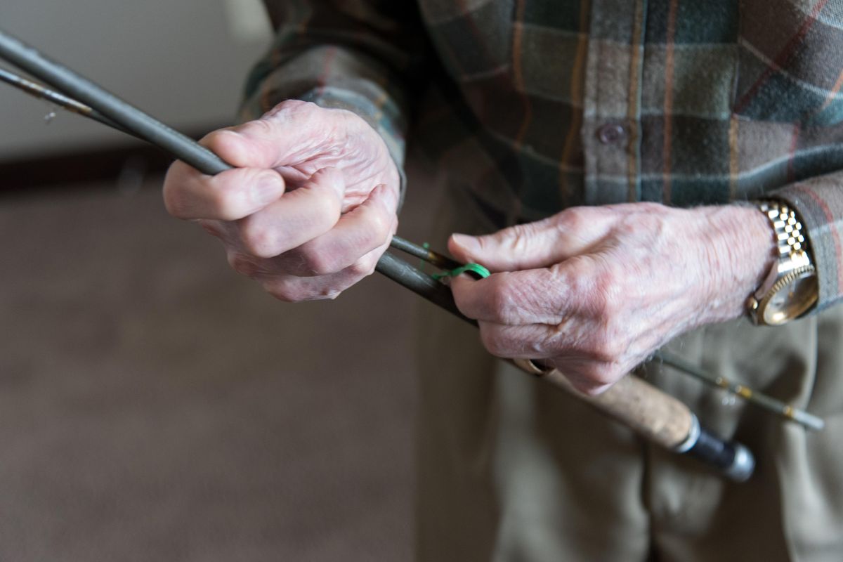 Bob Stephens holds a fly rod he bought 60 years ago. The 99-year-old still fishes regularly and just signed up for a fly fishing class. (Eli Francovich / The Spokesman-Review)