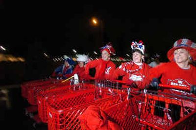 
Mikki Stevens, right, and some Red Hot Mamas run through the shopping-cart drill team routine they will perform during their trip to President Bush's second inauguration. They were practicing in the Target parking lot Thursday evening. 
 (Jesse Tinsley / The Spokesman-Review)