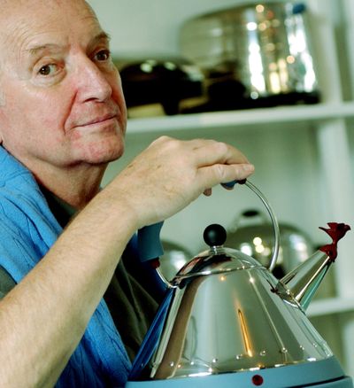 In this 2003 photo, architect and designer Michael Graves poses with a teakettle he designed at his studio in Princeton, N.J. (Associated Press)