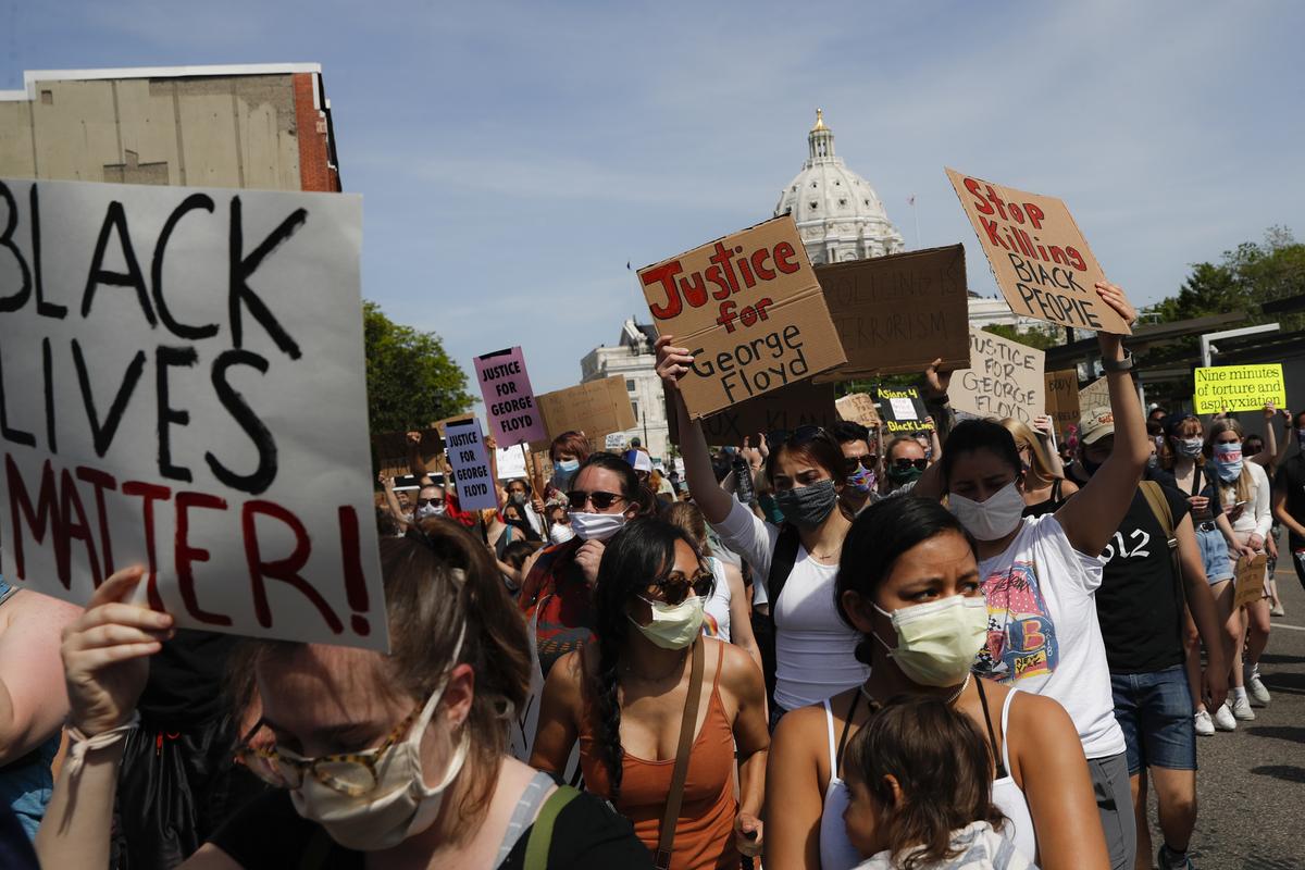 FILE - In this May 31, 2020, file photo, protesters march away from the State Capitol, in St. Paul, Minn. A loose network of Facebook groups that took root across the country in April to organize protests over coronavirus stay-at-home orders has become a hub of misinformation and conspiracies theories that have pivoted to a variety of new targets. Their latest: Black Lives Matter and the nationwide protests against racial injustice.  (John Minchillo)