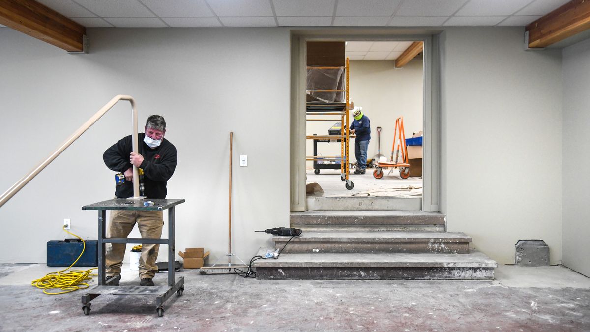 Tod Davin, of Krueger Sheet Metal, left, works on a stairway hand rail, and Tom Segura, of Pro Mechanical Services, does some cleanup Friday to finish the first two rooms at the Cannon Street shelter near downtown Spokane. A third room will be completed in December.  (DAN PELLE/THE SPOKESMAN-REVIEW)