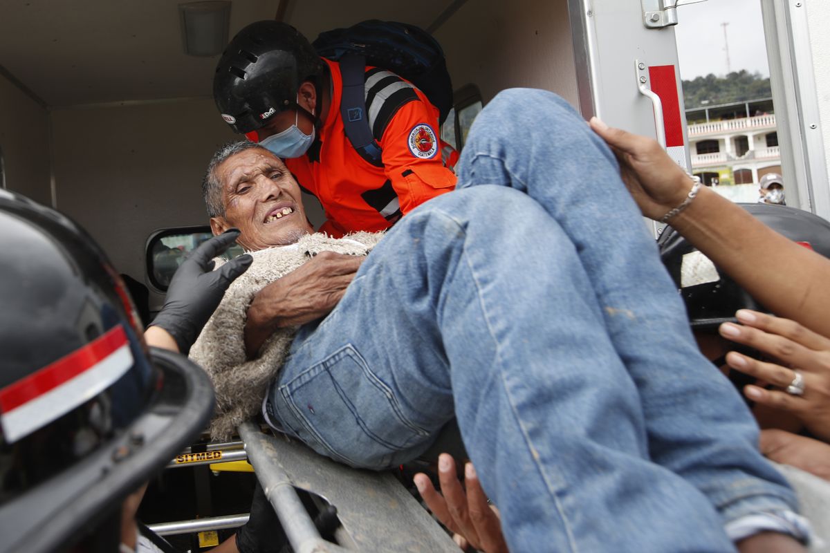 A man rescued from a zone where residents are believed buried by a massive, rain-fueled landslide, is placed into an ambulance Saturday in San Cristobal Verapaz, Guatemala.  (Moises Castillo)