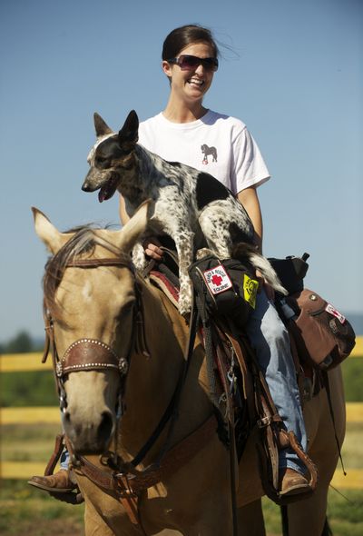 Mandy Wilson of Dauntless Equine Response rides her horse, Sugar, with her Australian cattle dog, Annie, at her Brush Prairie, Wash., home and training arena. (Associated Press)