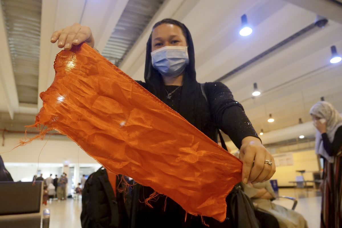 Amina, only name given to protect her identity, shows a red scarf worn by women activists of Nove Onlus, an Italian NGO working for women rights in Afghanistan, to identify themselves to Italian military at the Kabul airport in order to be evacuated, upon arriving at Rome