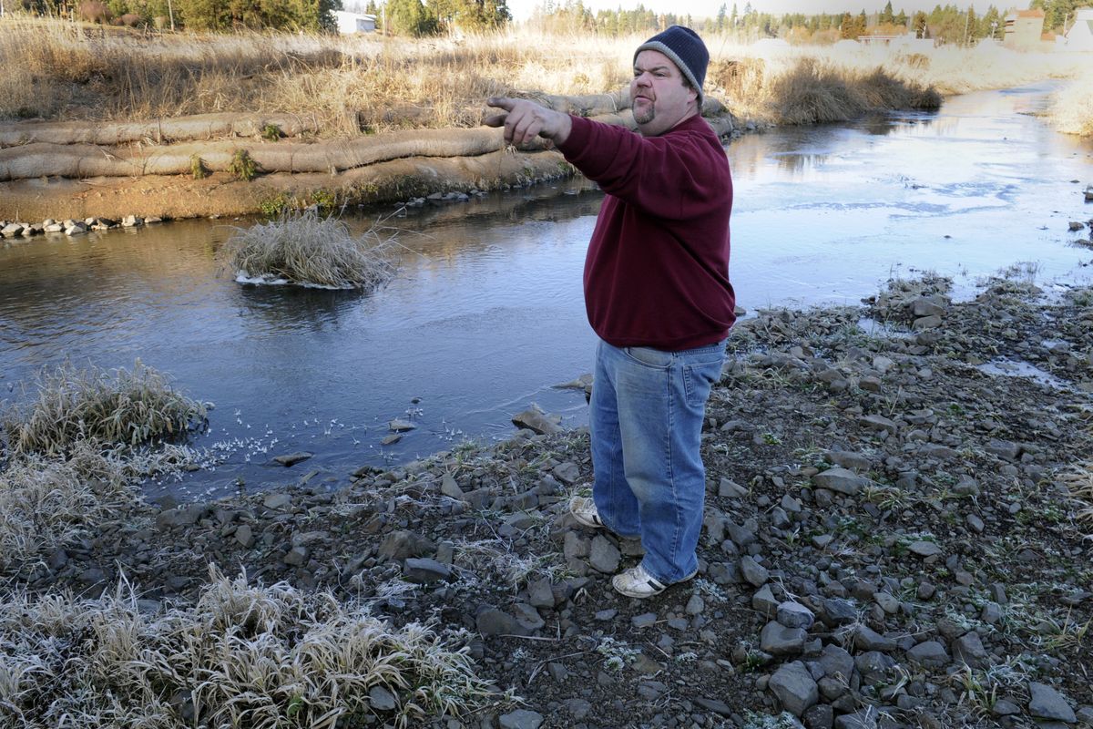 Former Rockford public works director Paul Sifford points to newly planted shade trees along Rock Creek Wednesday. Across the stream, fabric rolls have been placed to help control erosion. (J. BarT RAYNIAK)