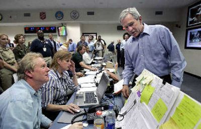 
President Bush looks over the work area of Randy Fritz, of the Texas Department of State Health Services, during his visit to the Texas Emergency Operations Center in Austin on Saturday to monitor the damage from Hurricane Rita. 
 (Associated Press / The Spokesman-Review)