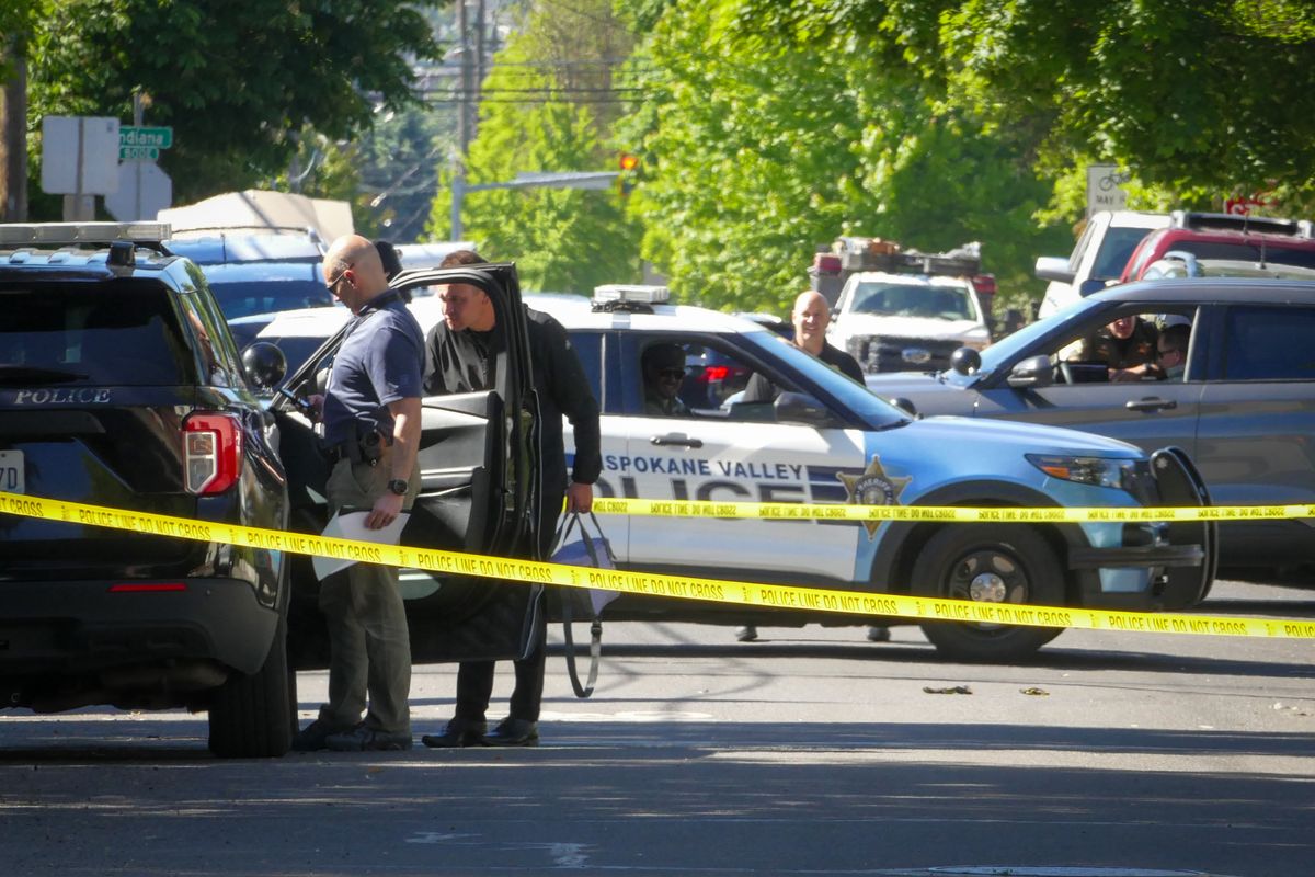 Police vehicles park at and restrict access to the intersection of Cincinnati Street and Baldwin Avenue on Thursday after an early morning police shooting at the scene of a domestic violence call in the Logan Neighborhood of Spokane. (Jesse Tinsley/THE SPOKESMAN-REVI)
