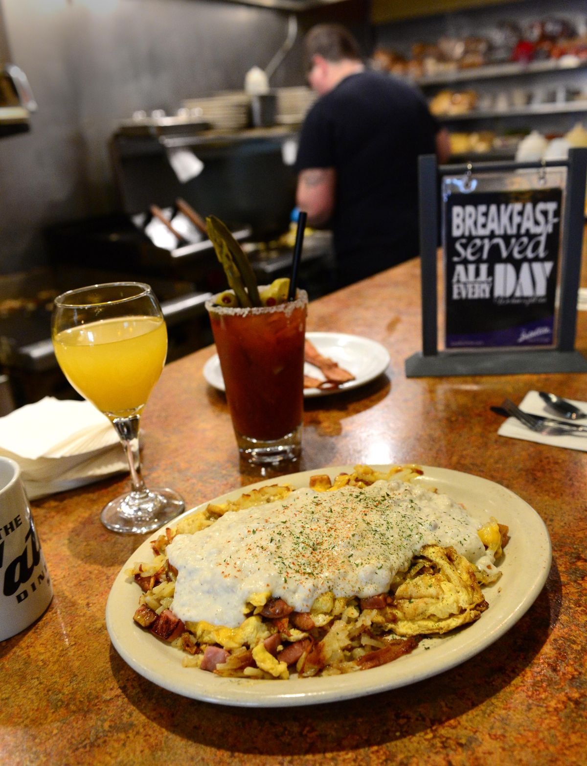 The Satellite Scramble is one of the most popular dishes at the Satellite Diner, shown Wednesday, Dec. 28, 2016. In the background is ace line cook, Elise Manship. (Jesse Tinsley / The Spokesman-Review)