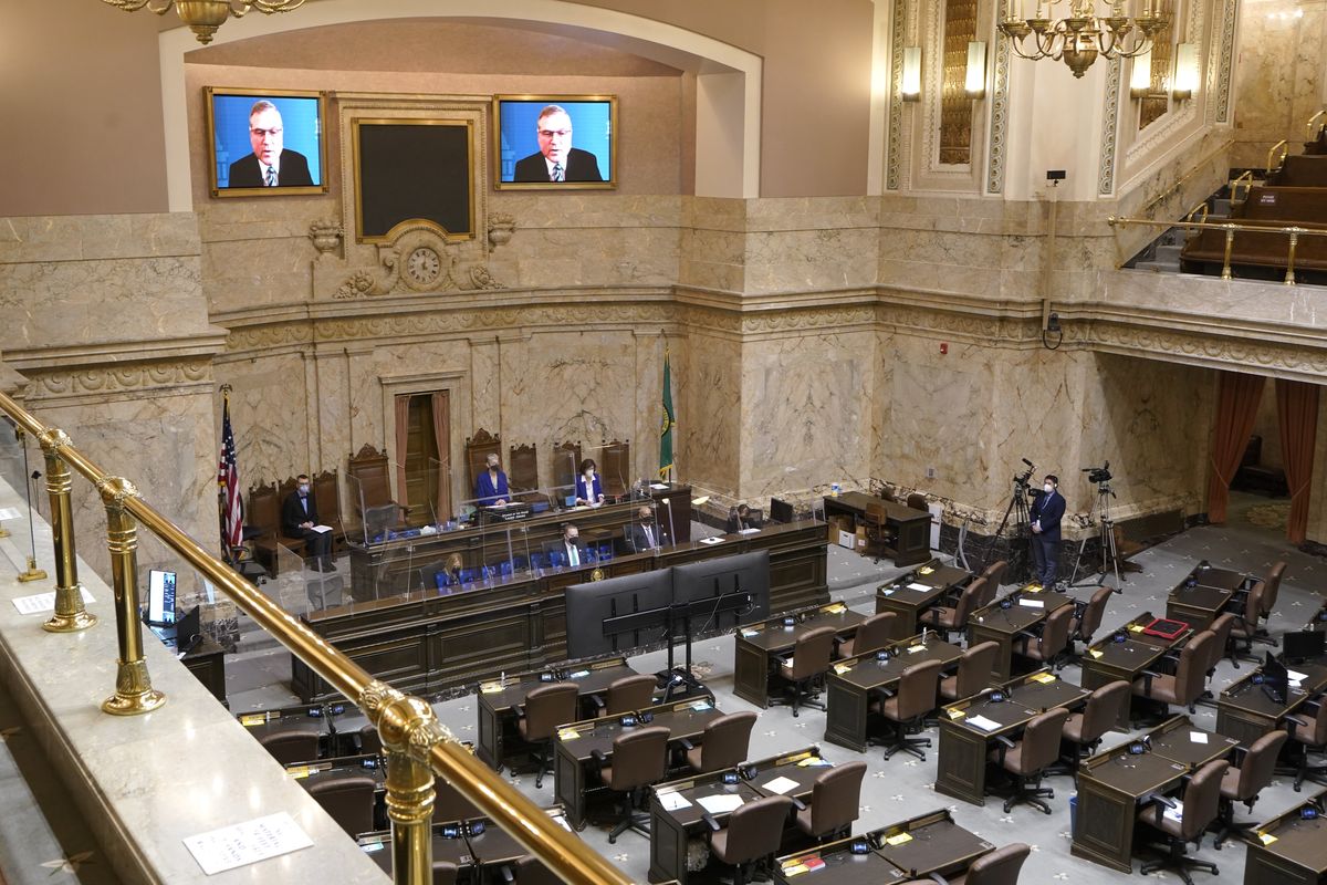 FILE - House Republican Leader J.T. Wilcox, R-Yelm, is displayed on video screens as he speaks remotely following opening remarks from House Speaker Laurie Jinkins, D-Tacoma, during the opening session of the Washington state House, Jan. 10, 2022, at the Capitol in Olympia, Wash. As lawmakers in some Democratic-led states meet remotely because of renewed COVID-19 concerns, their counterparts in many Republican-led legislatures are beginning their 2022 sessions with an aggressive push to outlaw vaccine requirements in workplaces and schools and roll back the government’s power to mandate pandemic precautions.  (Ted S. Warren)