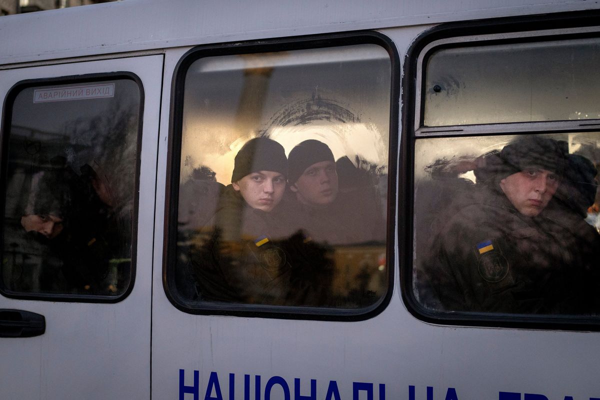 Members of National Guard of Ukraine look out of the window as they ride in a bus through the city of Kyiv, Monday, Feb. 14, 2022. More NATO troops headed to Eastern Europe and some nations worked to move their citizens and diplomats out of Ukraine on Monday, as Germany’s chancellor made a last-ditch attempt to head off a feared Russian invasion that some warn could be just days away.  (Emilio Morenatti)