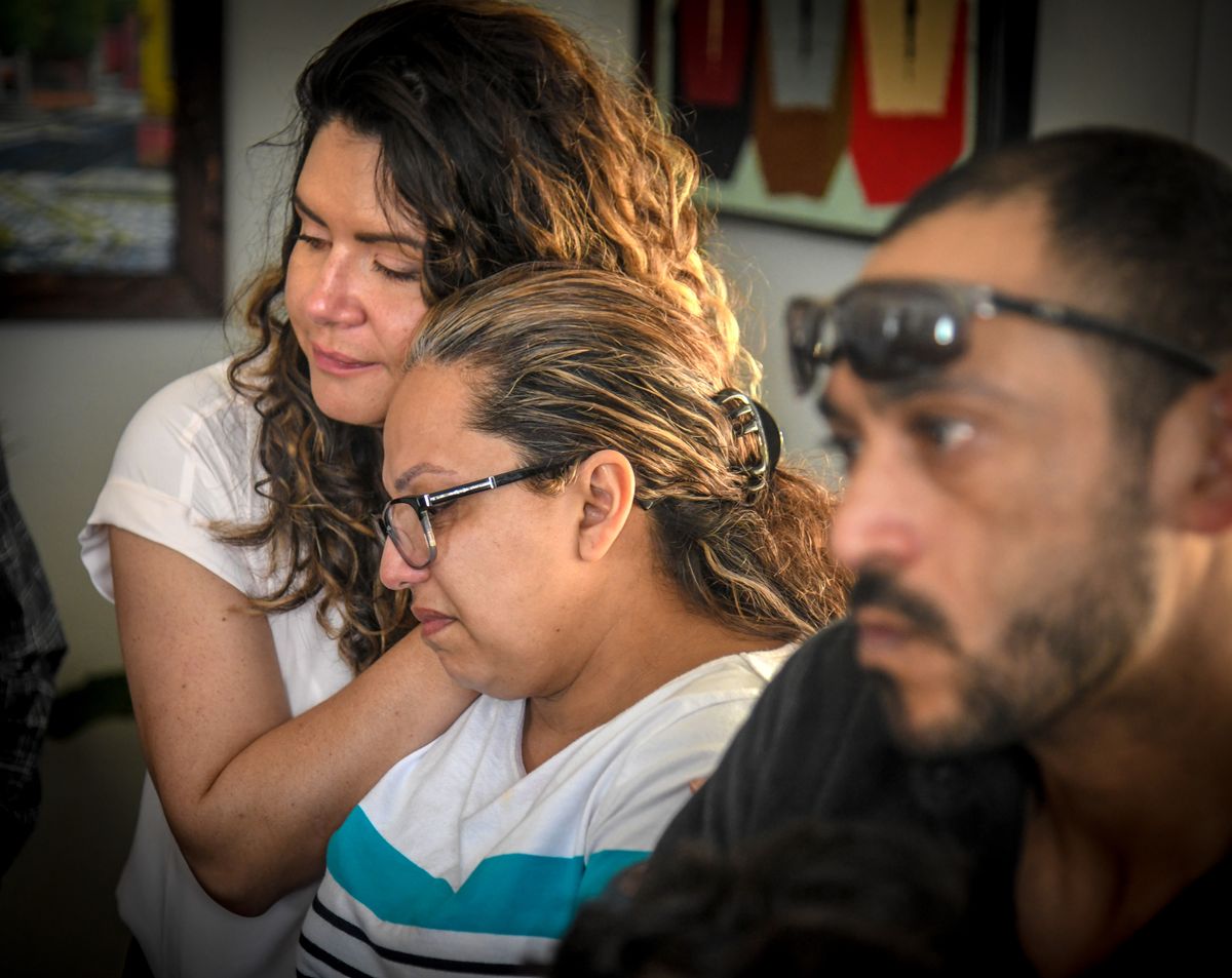 Jennyfer Mesa, left, offers comfort and understanding to Dania Salgado as she and her husband, Jose Luis Arias, talk about how Dania and her three children left Honduras for the U.S.  (DAN PELLE/THE SPOKESMAN-REVIEW)