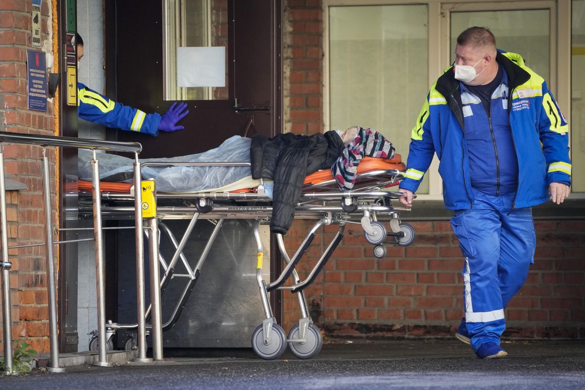 Medical workers carry a patient suspected of having coronavirus on a stretcher at a hospital for COVID-19 patients in St. Petersburg, Russia, Friday, Oct. 29, 2021. Russia on Friday recorded another record of daily coronavirus deaths as authorities hoped to stem contagion by keeping most people off work.  (Dmitri Lovetsky)