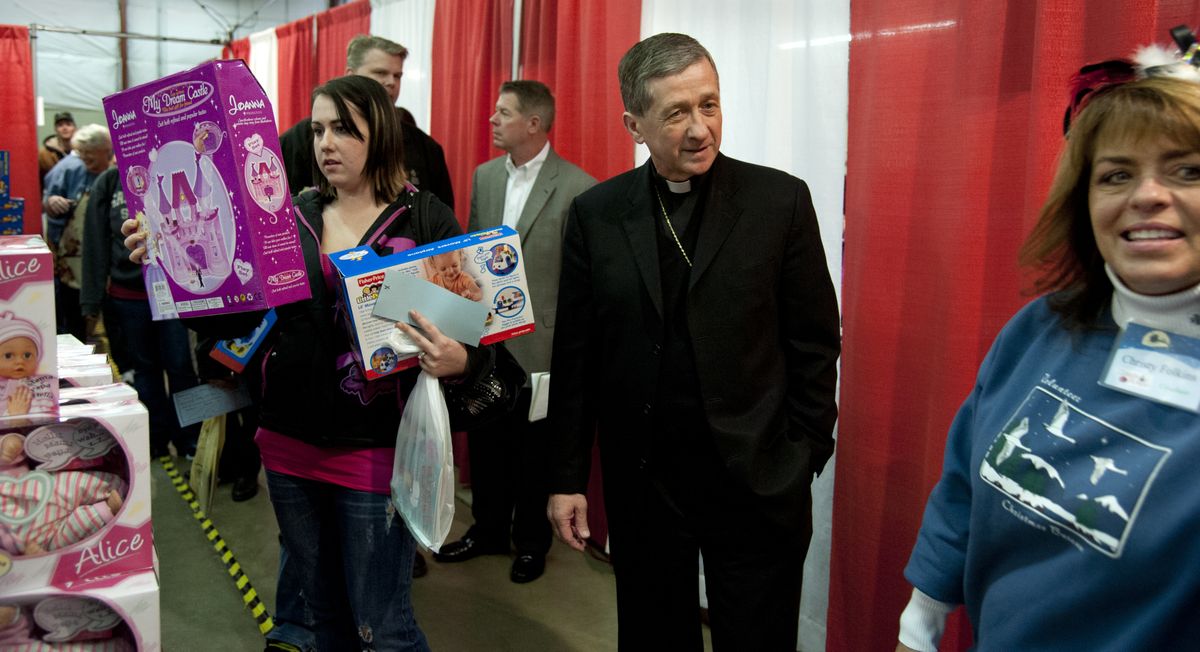 Christmas Bureau co-chairman Christy Folkins, right, gives Spokane Catholic Bishop Blase Cupich a tour of the bureau’s toy room as Melonie Myers, left, selects a present for her daughter on Wednesday at the Spokane County Interstate Fair and Expo Center. (Dan Pelle)