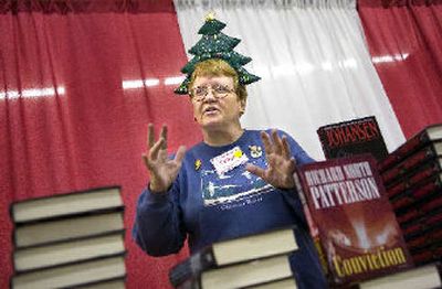 
Volunteer Fern Swecker hands out books on Wednesday, the Christmas Bureau's last day of operation for the year. 
 (Holly Pickett / The Spokesman-Review)