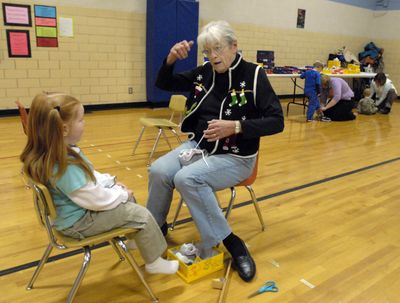 The Spokesman-Review “You’ve got to be able to run fast and jump high,” Harriet Jacobson tells Sophie Patterson as she adjusts her new shoes at Trentwood Elementary. (J. BART RAYNIAK / The Spokesman-Review)
