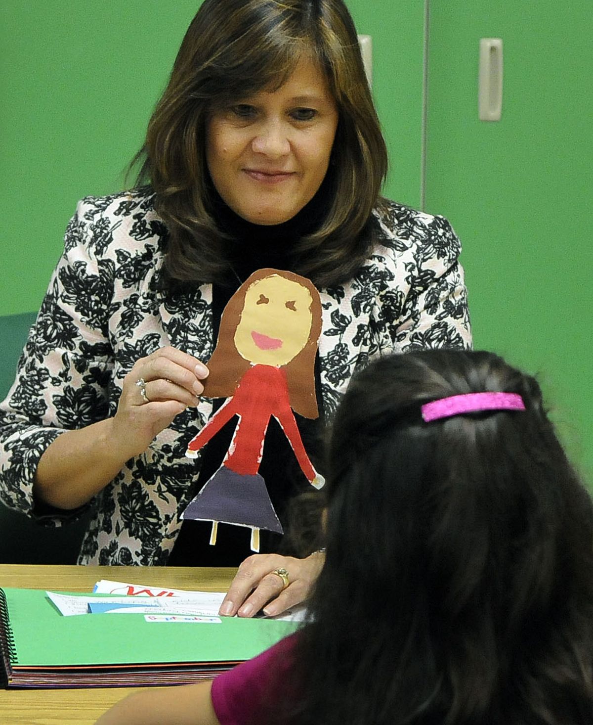 Woodridge Elementary School third-grade teacher Linda Sams shows Natalie Barton a drawing the student made of herself at the beginning of the school year. (Dan Pelle)