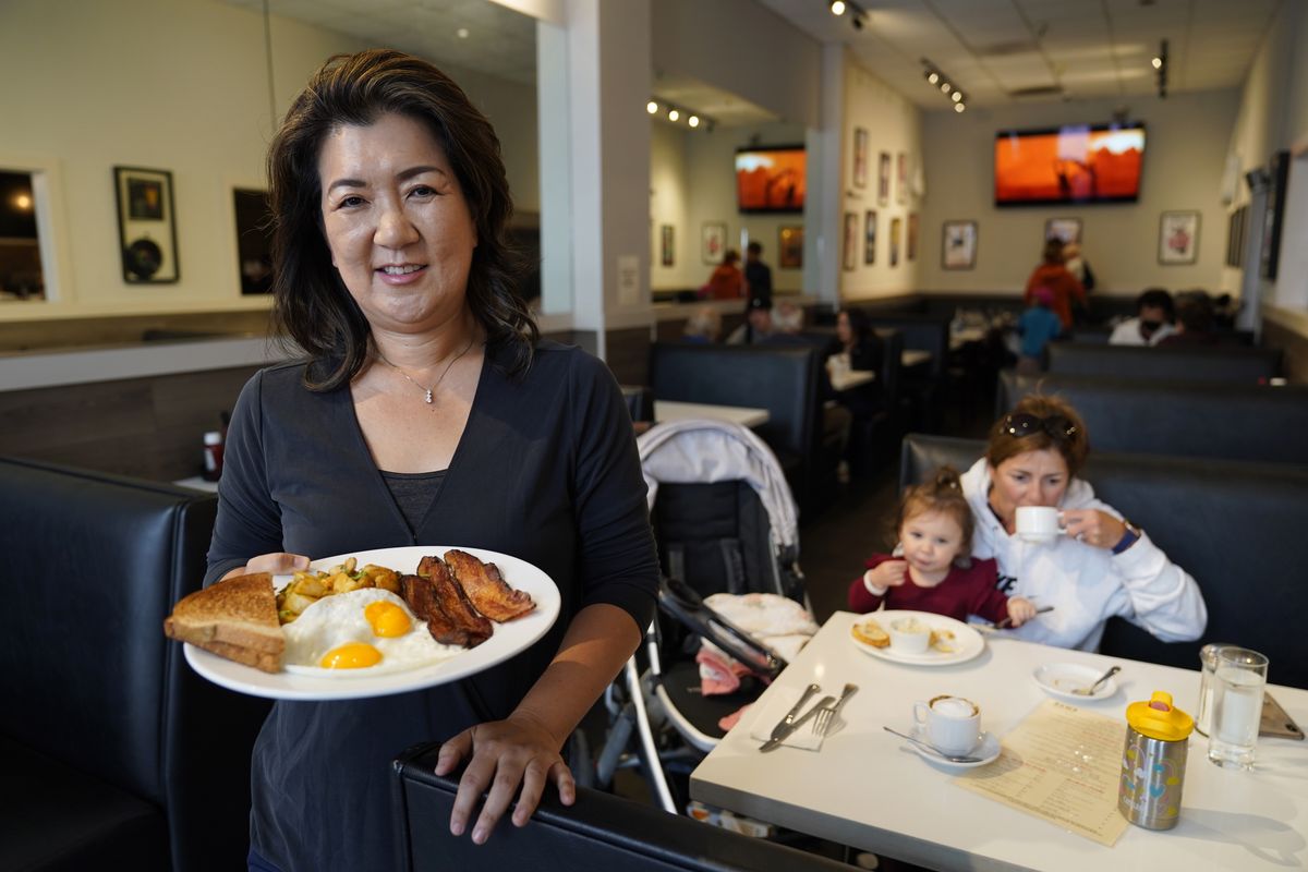 Jeannie Kim holds her popular bacon and eggs breakfast at her restaurant in San Francisco on Friday.  (Eric Risberg)