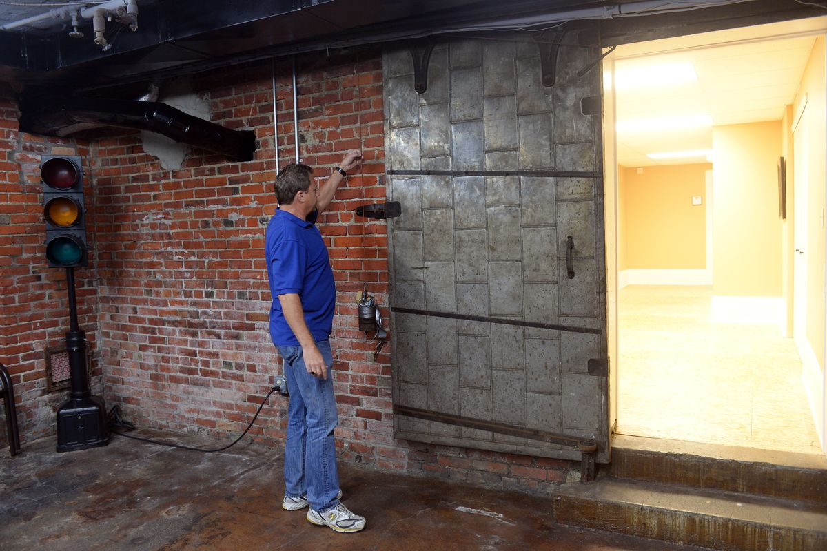 Steve Salvatori looks at an antique fire door in the recreation room in the basement of the Buchanan Building at 28 W. Third Ave. in downtown Spokane. The building, built in 1911, currently houses several small and midsize businesses. (Jesse Tinsley)
