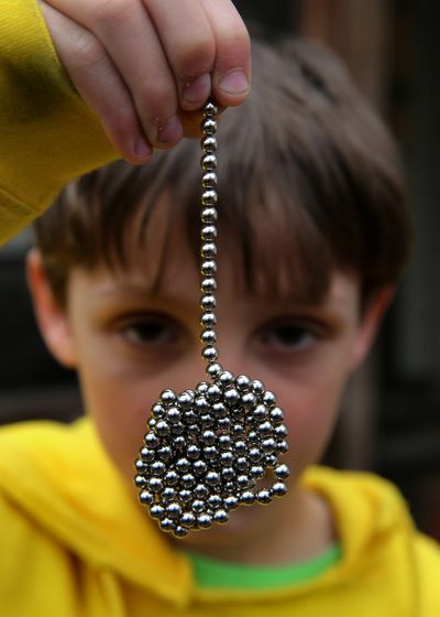Brandon Bruski, 9, holds dozens of Buckyballs on Thursday, April 11, 2013 in Crystal Lake, Illinois. In January, Brandon accidentally swallowed two balls from this set of the small magnetic desk toys. The magnets left Brandon with a small and large intestine bound together. Emergency surgery was required. (Chris Sweda/Chicago Tribune/MCT)  (Chris Sweda)