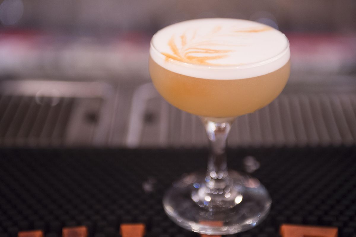 The classic Whiskey Sour, as prepared by Simon Moorby of the Hogwash, Whiskey Den, is seen here with artistic designs drawn with Angostura bitters on top. (Jesse Tinsley / The Spokesman-Review)