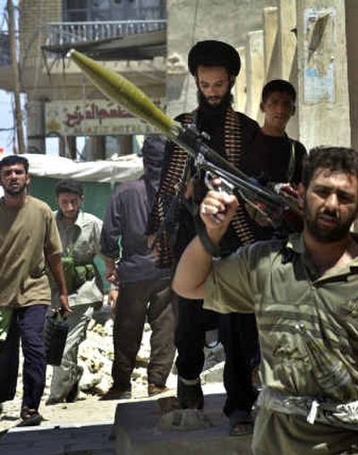 
Fighters loyal to Muqtada al-Sadr carry their weapons Sunday in Najaf, Iraq.
 (Associated Press / The Spokesman-Review)
