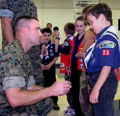 
Marine Maj. Jon Dunne  presents Nick Thomas and other members of Cub Scout Pack 91, Den 5 with  