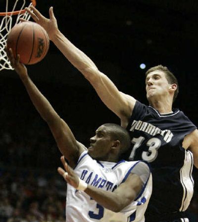
Monmouth's Corey Hallett blocks a shot by Hampton's Rashad West in the first half on Tuesday.
 (Associated Press / The Spokesman-Review)