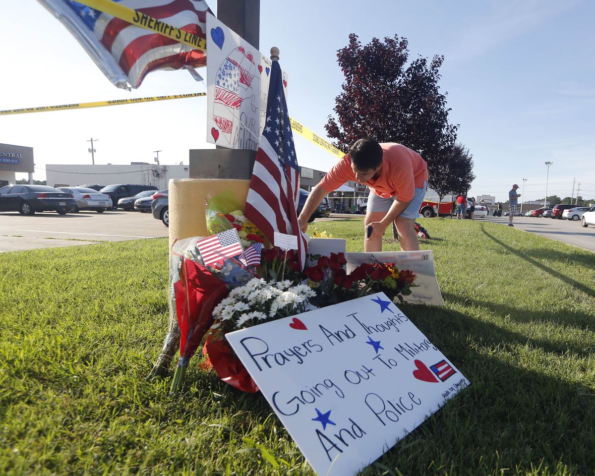 Houston Brock reads a note at a memorial outside an Armed Forces Career Center in Chattanooga, Tenn., where a gunman opened fire Thursday. (Associated Press)