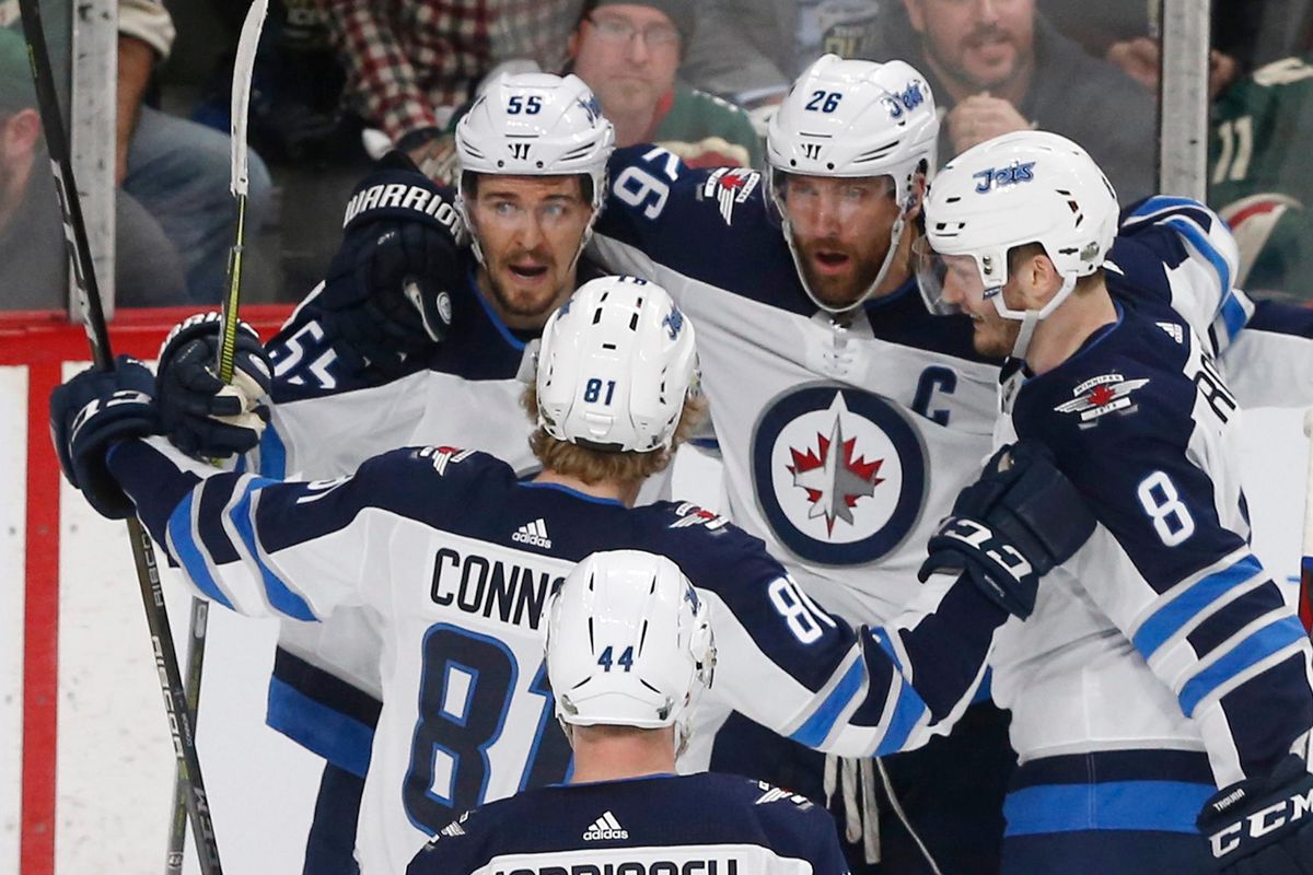 Winnipeg Jets celebrate with Mark Scheifele, top left, after he scored on Minnesota Wild goalie Devan Dubnyk during the first period of Game 4 of an NHL hockey first-round playoff series Tuesday, April 17, 2018, in St. Paul, Minn. (Jim Mone / Associated Press)